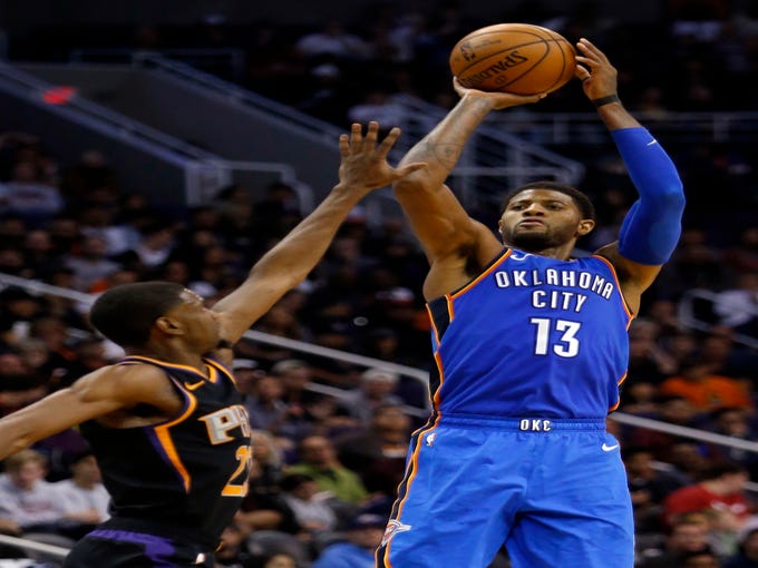Oklahoma City Thunder forward Paul George (13) shoots over Phoenix Suns forward Josh Jackson during the second half of an NBA basketball game Saturday, Nov. 17, 2018, in Phoenix. Oklahoma City won 110-100. (AP Photo/Rick Scuteri)