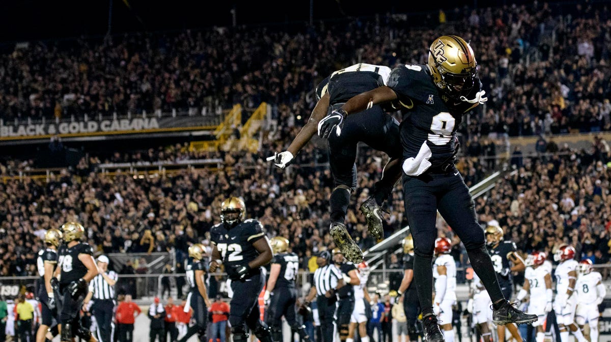 UCF  running back Greg McCray (30) celebrates his touchdown with teammate  Adrian Killins Jr.