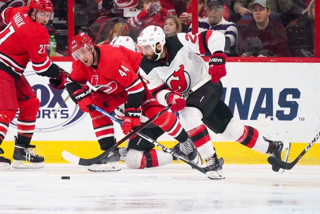 New Jersey Devils right wing Kyle Palmieri (21) skates with the puck past Carolina Hurricanes defenseman Calvin de Haan (44) during the second period at PNC Arena.