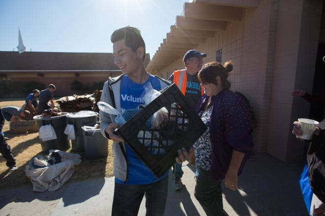 Juan Sanchez, center,  a volunteer at the Casa de Peregrinos Thanksgiving Food Basket distribution at Calvary Baptist Church, helps Louise Gonzales and Joe Gonzales get a box filed with a turkey, potatoes and other food items for Thanksgiving to their car, Monday November 19, 2018.