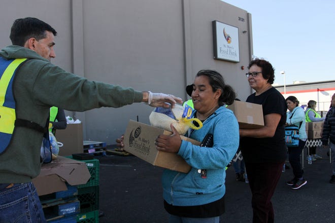 St. Mary's Food Bank volunteers give out turkeys during the three-day Thanksgiving food drive in Phoenix on Monday, Nov. 19, 2018.