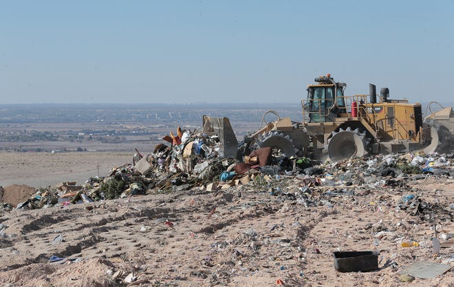 Heavy machinery compacts trash at the Greater El Paso Landfill just above the Clint valley, which can be seen in the background.
