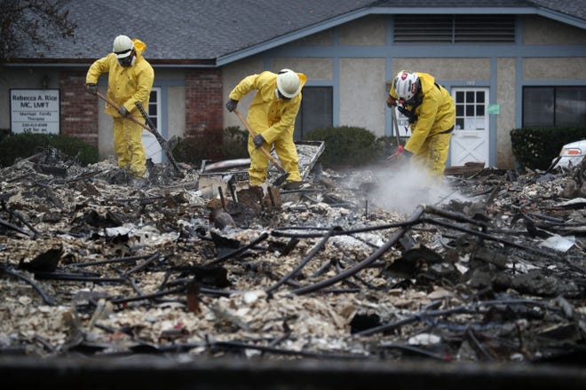 Search and rescue crews dig through the burnt remains of a business as they search for human remains on November 21, 2018 in Paradise, Calif. Fueled by high winds and low humidity the Camp Fire ripped through the town of Paradise charring over 150,000 acres, killed at least 81 people and has destroyed over 18,000 homes and businesses. The fire is currently at 80 percent containment and hundreds of people still remain missing. 