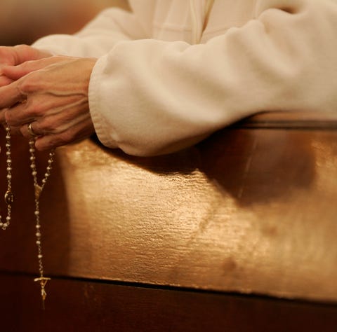 File picture - a woman holds a rosary during a...