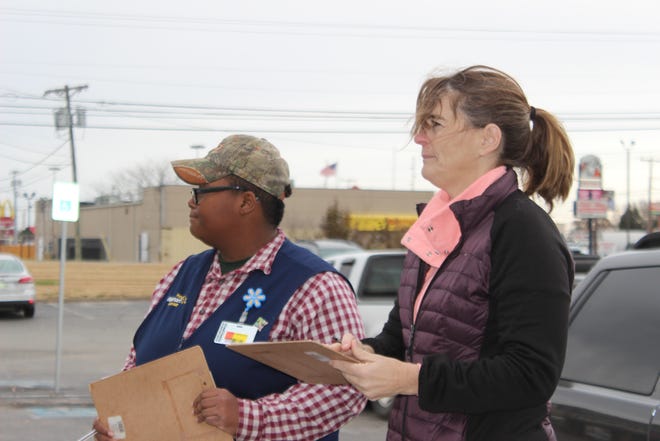 Clarksville teacher Caralee Harrison, right, stands outside the Goodwill on Fort Campbell Boulevard on Black Friday with her petition in hand in an effort to save the store.