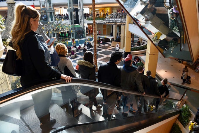 People pack an escalator at the Somerset Collection in Troy for Black Friday shopping .