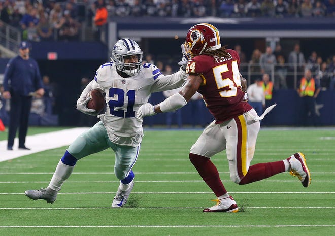 Dallas Cowboys running back Ezekiel Elliott  (21) holds off Washington's Mason Foster on a run in the fourth quarter at AT&T Stadium on Thursday.