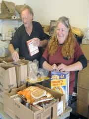 Volunteers Jeff Web and Mary Guthrie fill bags of food at the Yerington Food Pantry.