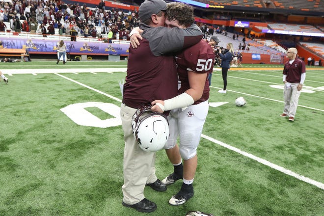 Aquinas Institute Head Coach Derek Annechino and his son Nick cry and celebrate their victory over New Rochelle 21-14 to win the state football championship.