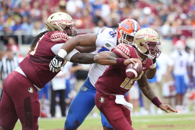 Florida State Seminoles quarterback Deondre Francois (12) dodges the defense while looking to pass as the Florida State Seminoles take on their rival the Florida Gators in college football at Doak S. Campbell Stadium, Saturday, Nov. 24, 2018. 
