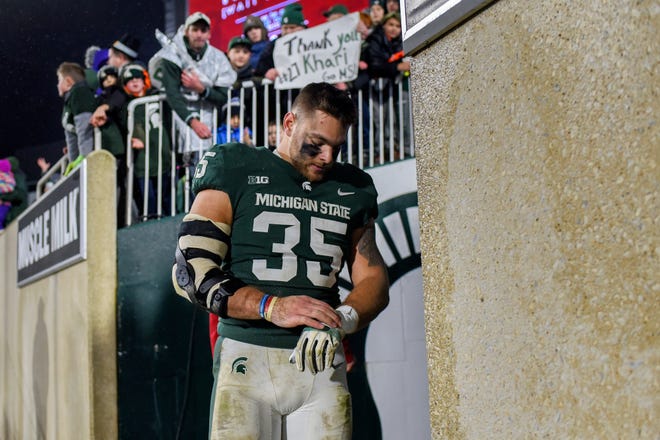 Michigan State's Joe Bachie takes off his gloves for a fan after the game on Saturday, Nov. 24, 2018, at Spartan Stadium in East Lansing.