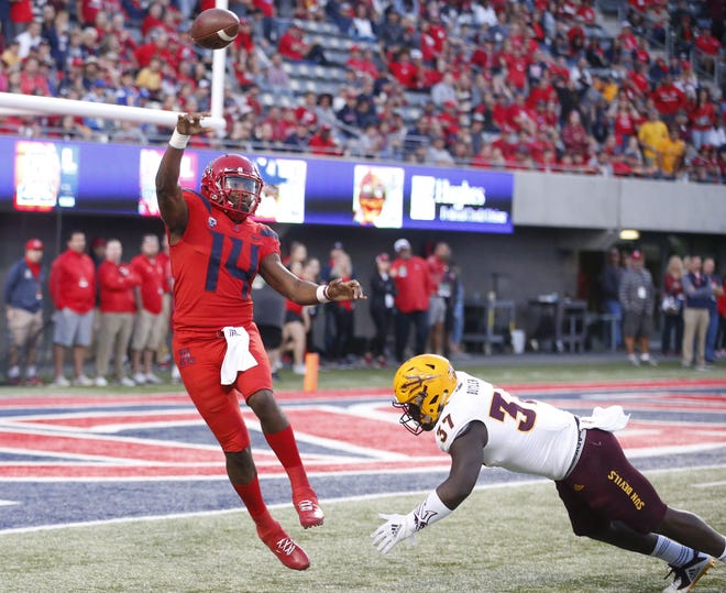 Arizona Wildcats quarterback Khalil Tate (14) passes the ball before being tackled by Arizona State Sun Devils linebacker Darien Butler (37) during the Territorial Cup football game at Arizona Stadium in Tucson on November 24.