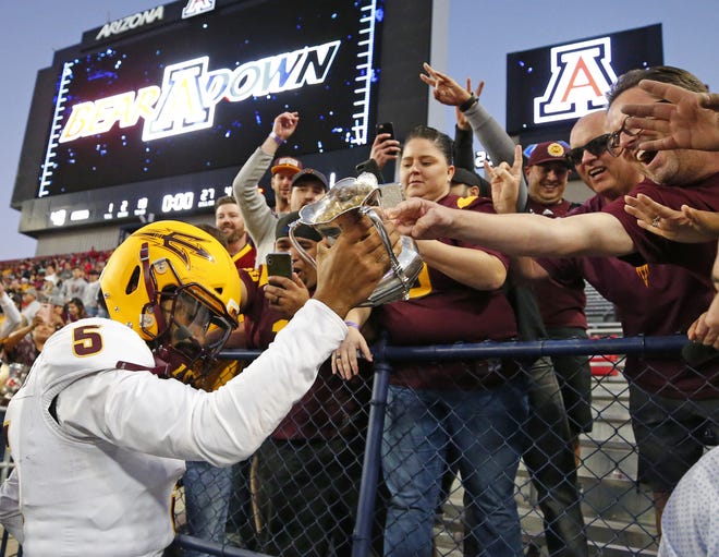 Arizona State Sun Devils quarterback Manny Wilkins (5) takes the cup to the fans after defeating Arizona Wildcats in  the Territorial Cup football game at Arizona Stadium in Tucson on November 24.