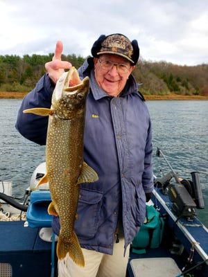 Ken Esser, who brought fame to the use of white ball-shaped maribu 3/4 ounce jigs at Round Valley, is shown while fishing with steady reader John Korn at "The Valley", holding what was estimated to be a 4-lb lake trout before they released it. Ken was pulling a steel shad blade bait when the fish hit.