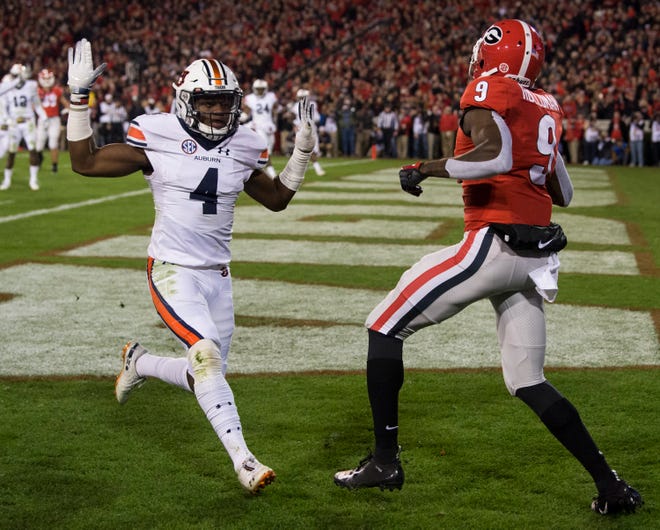 Auburn defensive back Noah Igbinoghene (4) puts his hands up after deflecting a pass in the end zone intended for Georgia wide receiver Jeremiah Holloman (9) at Sanford Stadium in Athens, Ga., on Saturday, Nov. 10, 2018. Georgia leads Auburn 20-10 at halftime.
