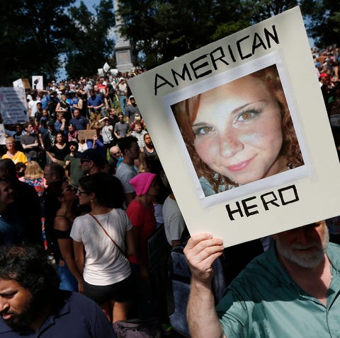 A counter-protester holds a photo of Heather...