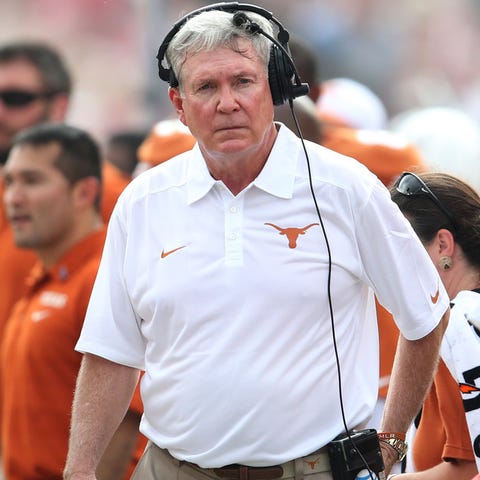 Mack Brown stands on the sideline while coaching...