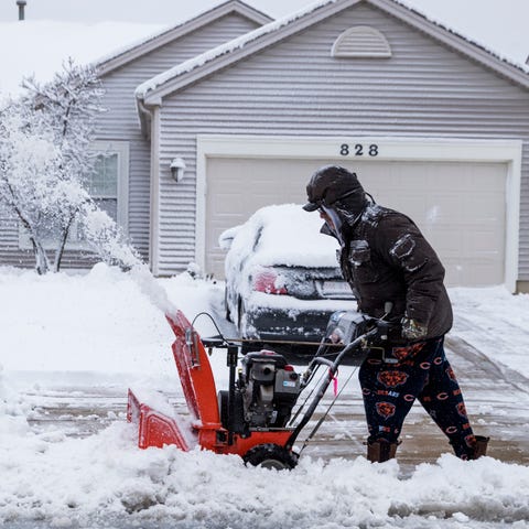 A man uses a snow blower on Nov. 26, 2018, to...