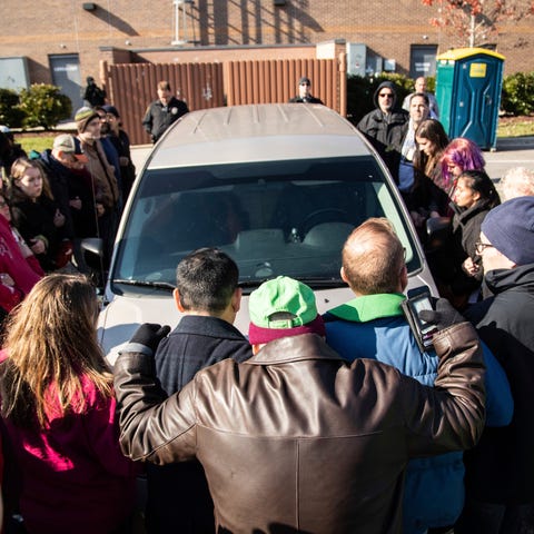 Demonstrators surround a government vehicle after...