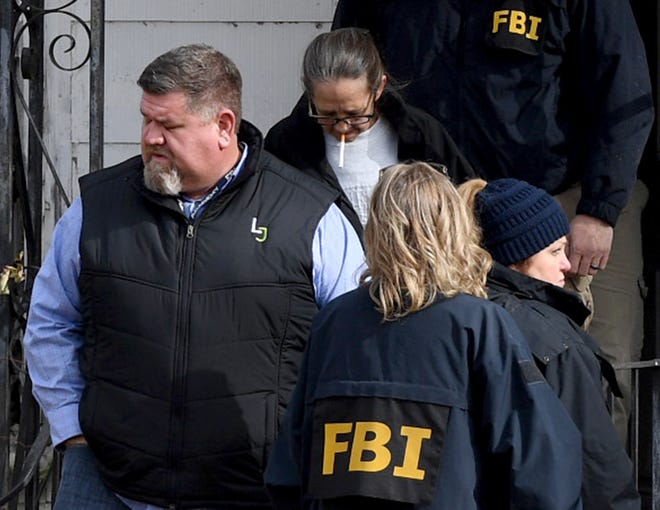 FBI agents lead Cindy McDaniel outside her old home Wednesday, Nov. 28, 2018. Evidence Response Team agents were called in to assist in the 22-year-old missing persons case of Cayce McDaniel by searching and collecting evidence in the home.