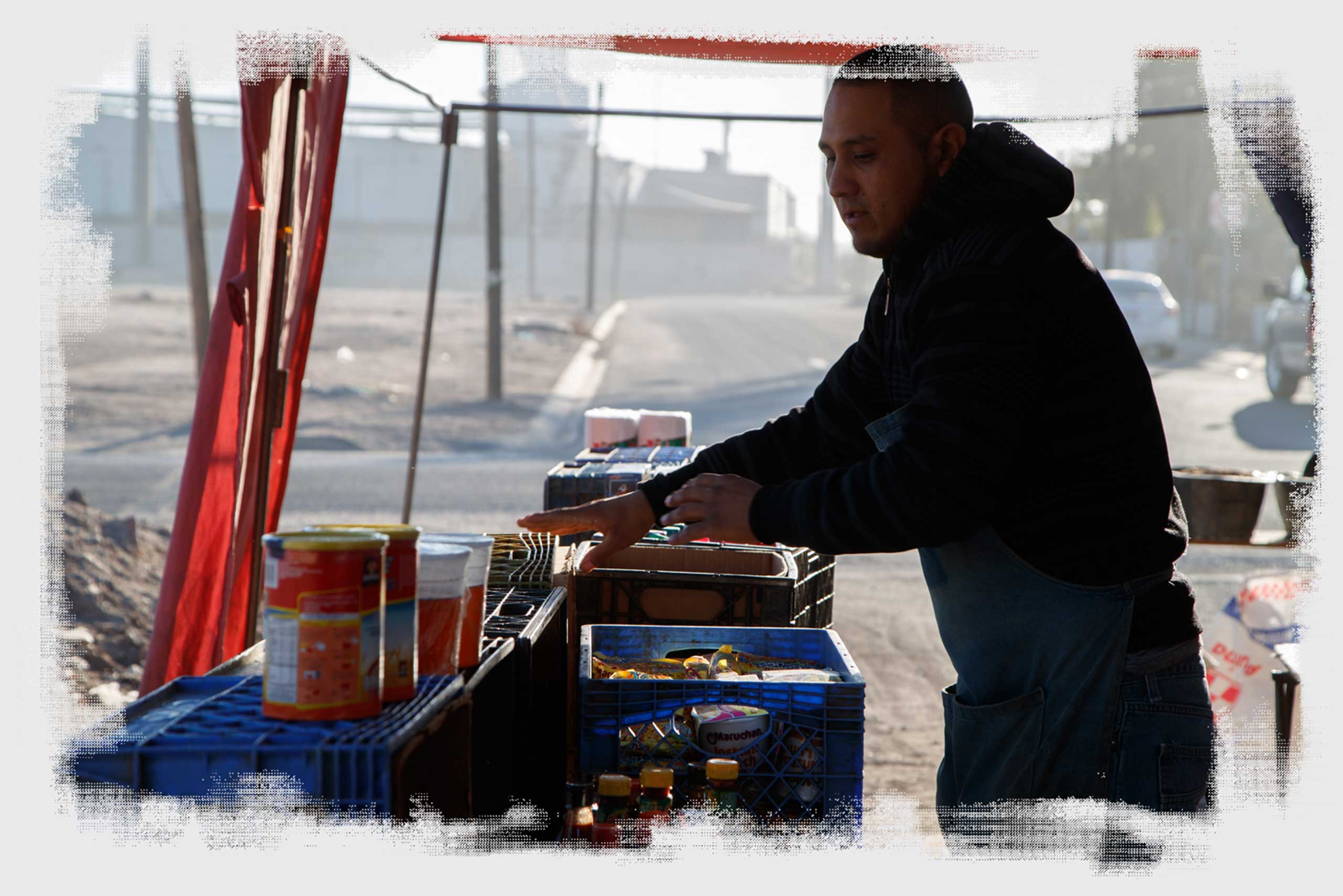 Luis Alberto Rodríguez lays out food at a street market in a neighborhood next to a row of factories in Mexicali.