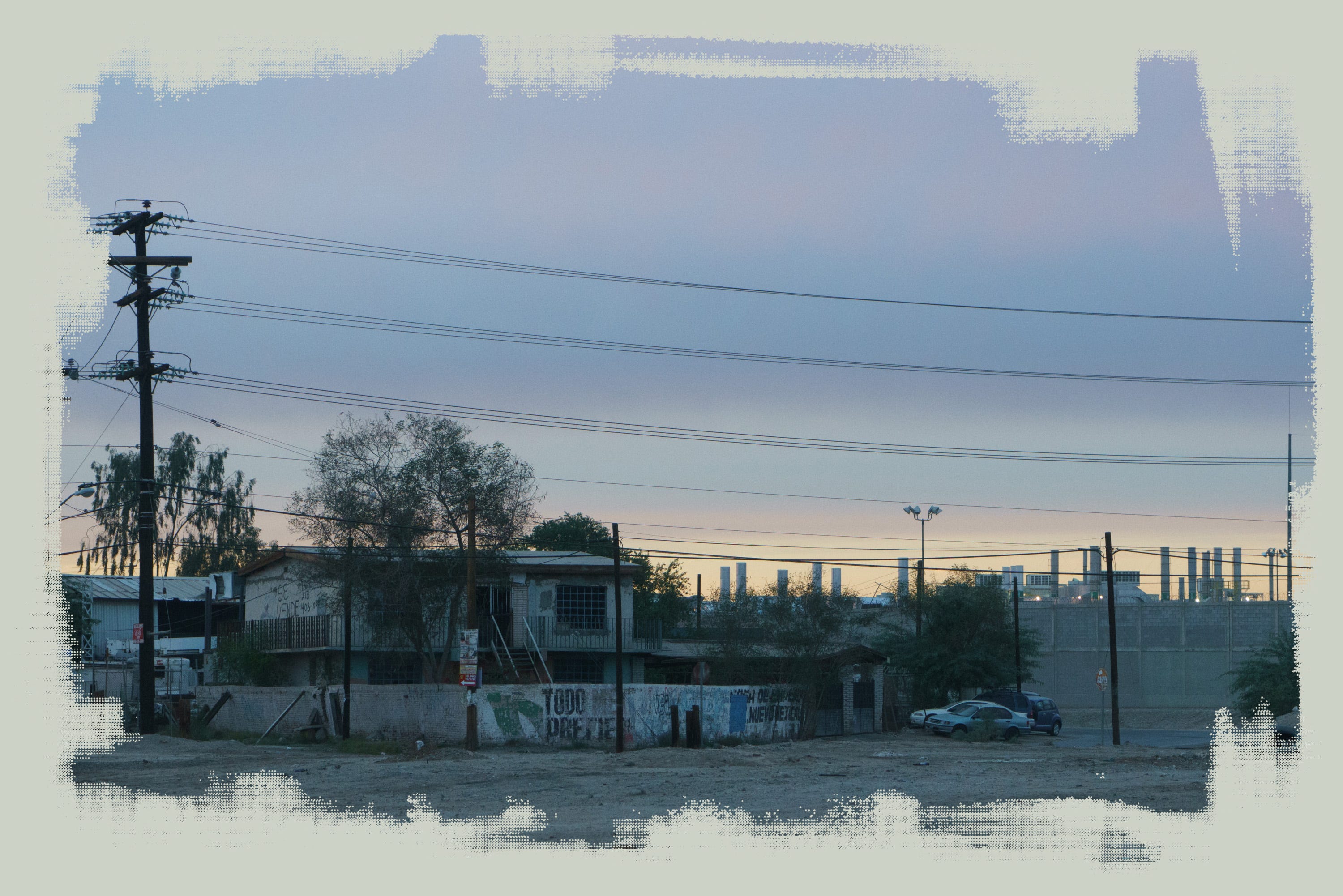 The Kenworth truck factory’s smokestacks rise behind houses in Mexicali.