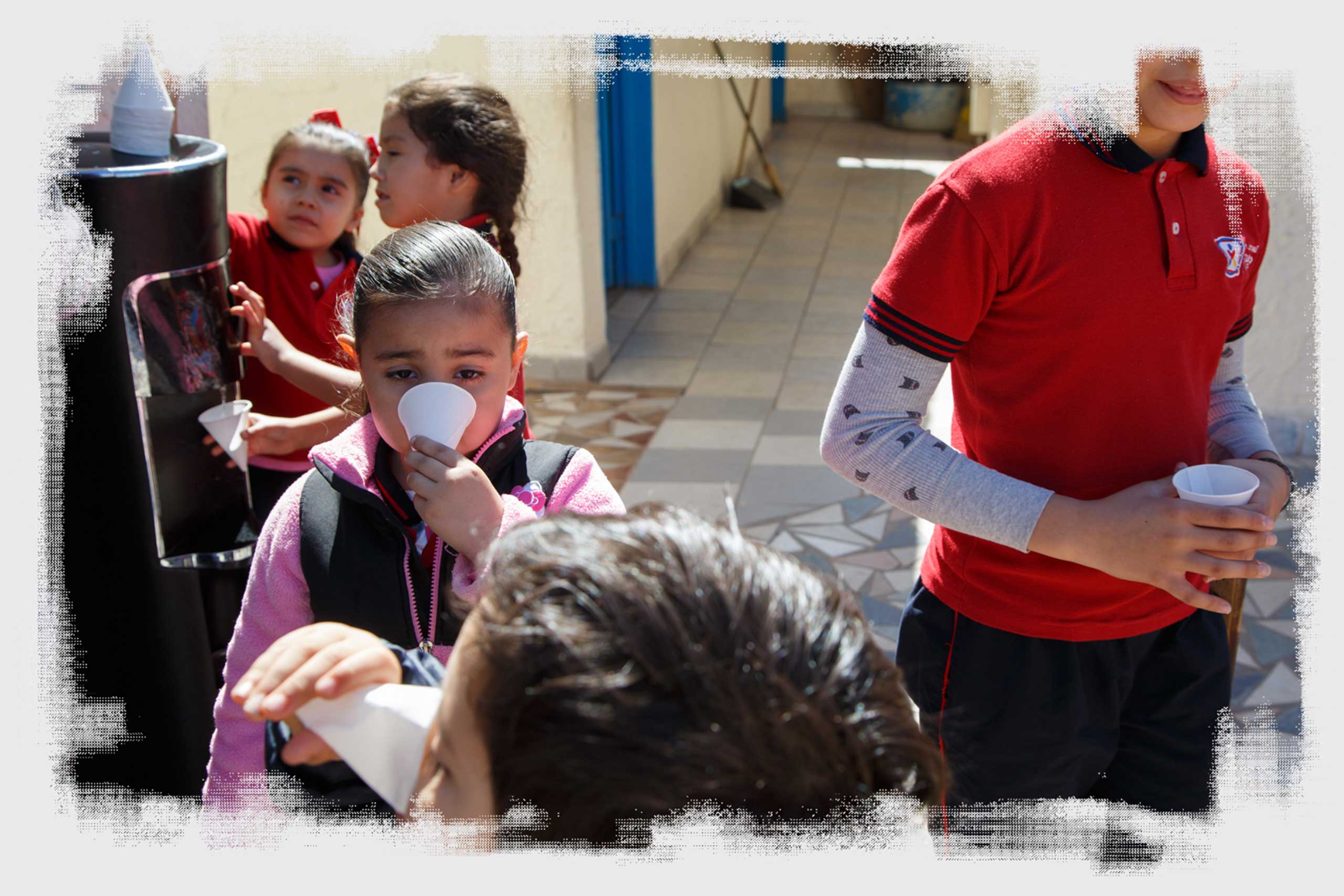 Students drink water from a cooler at Leonardo da Vinci Integral School in Mexicali.