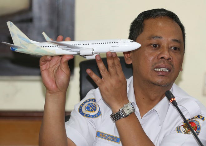 National Transportation Safety Committee investigator Nurcahyo Utomo holds a model of an airplane during a press conference on the committee's preliminary findings on their investigation on the crash of Lion Air flight 610, in Jakarta, Indonesia, Wednesday, Nov. 28, 2018.