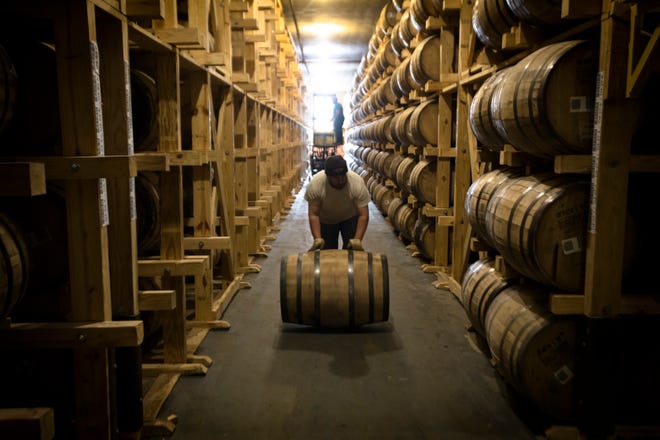 An employee of Buffalo Trace rolls a barrel of bourbon to be bottled at Buffalo Trace Distillery in Frankfort, Ky., on Wednesday, Nov. 28, 2018.