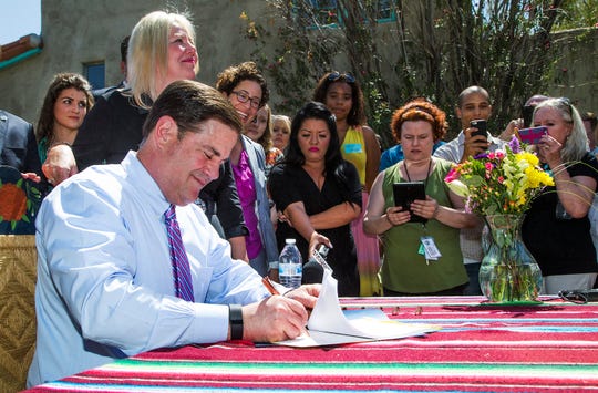 Gov. Doug Ducey signs a bill on June 1, 2016 limiting regulations on short-term rental properties.