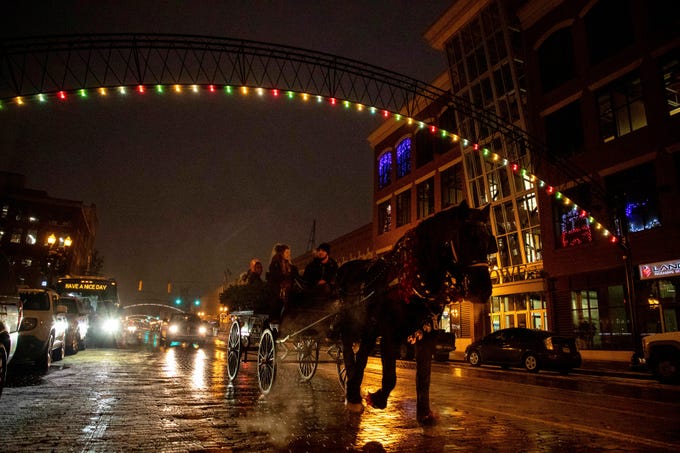 A carriage makes its way down Saginaw Street during the Christmas tree lighting celebration on Thursday, Nov. 29, 2018, in downtown Flint, Mich.