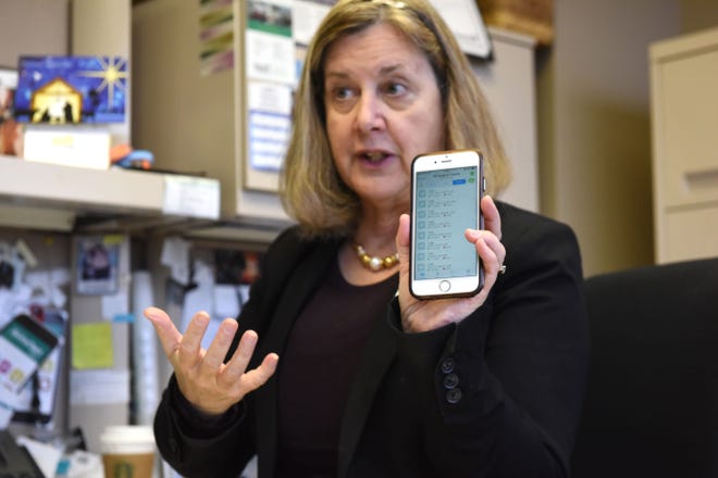 Candice Friestad, Avera Health's director of clinical informatics, holds up her phone with the app Voalte displayed, Thursday, Nov. 29, 2018 in Sioux Falls, S.D.