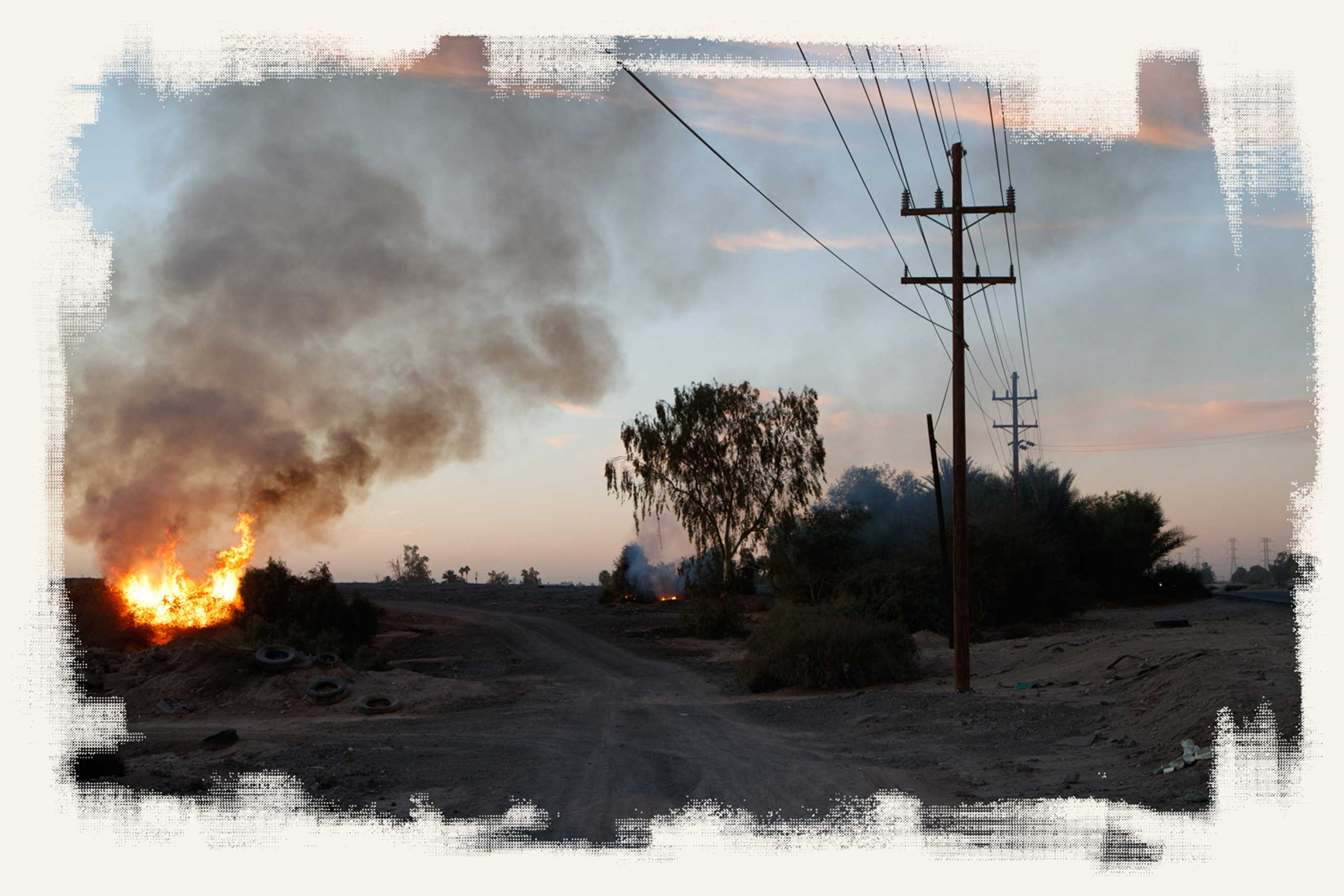 Smoke billows from burning trash next to the Grupo Simec steel mill in the countryside southeast of Mexicali.