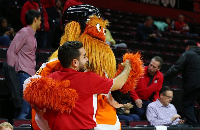 Gritty, the mascot of the Philadelphia Flyers NHL hockey team, dances with an usher before a college basketball game between the Michigan State Spartans and Rutgers Scarlet Knights at the Rutgers Athletic Center on November 30, 2018 in Piscataway, New Jersey.