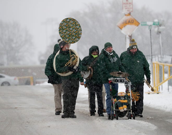 The Packers Tailgate Band makes its way through the snow before playing for tailgaters before the Green Bay Packers game against the Arizona Cardinals at Lambeau Field in Green Bay on  Dec. 2, 2018.