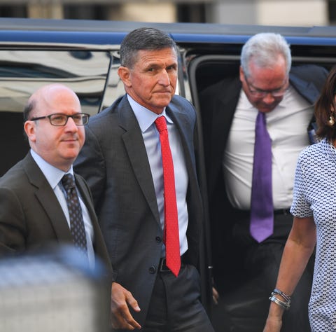 Lawyers escort Michael Flynn into a Washington...