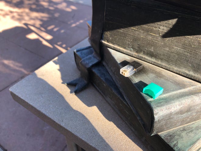 An e-cigarette pod left on a book statue on Linn Street Wednesday Dec. 5.