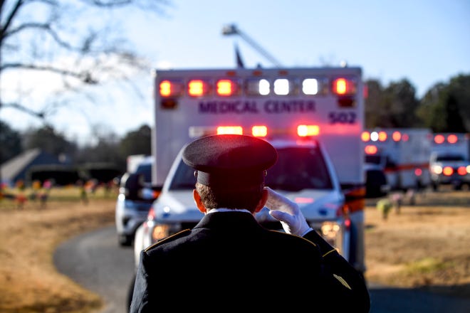 Officer Steffen salutes each ambulance and it's occupants as they drive in a procession to the funeral of Zachary Pruitt at Highland Memorial Gardens in Jackson, Tenn., on Wednesday, Dec. 5, 2018. 
