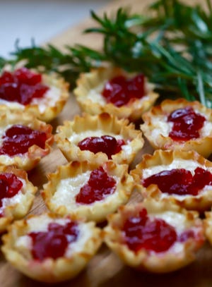 Easy Cranberry Brie Bites are garnished with sprigs of rosemary.