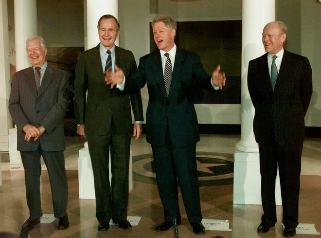 Former Presidents Jimmy Carter, left, George H.W. Bush, and Gerald Ford, right, laugh as President Clinton speaks during a photo session in front of a replica of the White House at the George Bush Presidential Library in College Station, Texas, Thursday, Nov. 6, 1997, prior to the library dedication ceremonies. 