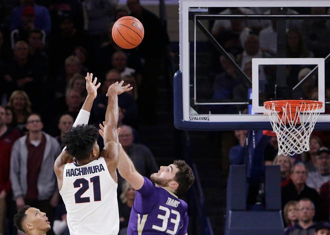 Gonzaga forward Rui Hachimura (21) shoots the go-ahead basket while defended by Washington forward Sam Timmins (33) during the second half of an NCAA college basketball game in Spokane, Wash., Wednesday, Dec. 5, 2018. Gonzaga won 81-79. (AP Photo/Young Kwak)