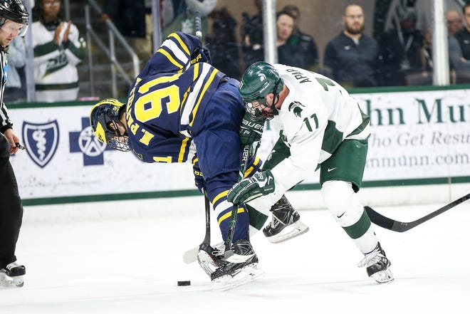 Tommy Apap fights for the puck with Michigan's  Nick Pastujov on Nov. 30, 2018. The Spartans defeated the Wolverines 4-3 and went on to sweep the series against them on Saturday.