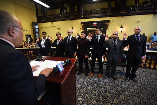 Roger Then, second from right, is sworn in as a Paterson police officer along with six other recruits in 2016.