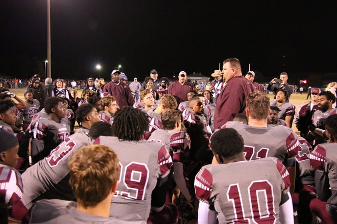 Madison County head coach Mike Coe talks to his team after a football game.
