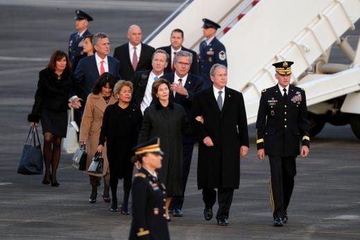 Former President George W. Bush and family members of former President George H.W. Bush walk off Special Air Mission 41 as the casket arrives at Ellington Field Wednesday, Dec. 5, 2018, in Houston. 