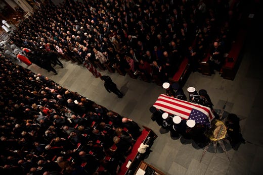 The flag-draped casket of former President George H.W. Bush is carried by a joint services military honor guard into St. Martin's Episcopal Church Thursday, Dec. 6, 2018, in Houston.