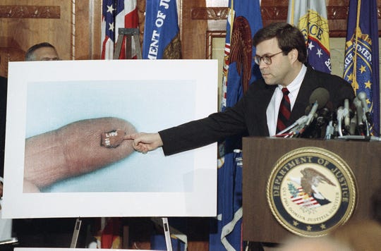 U.S. Attorney General William Barr points to a fragment of a circuit board during a news conference on Pan Am Flight 103 in Washington, Thursday, Nov. 14, 1991.