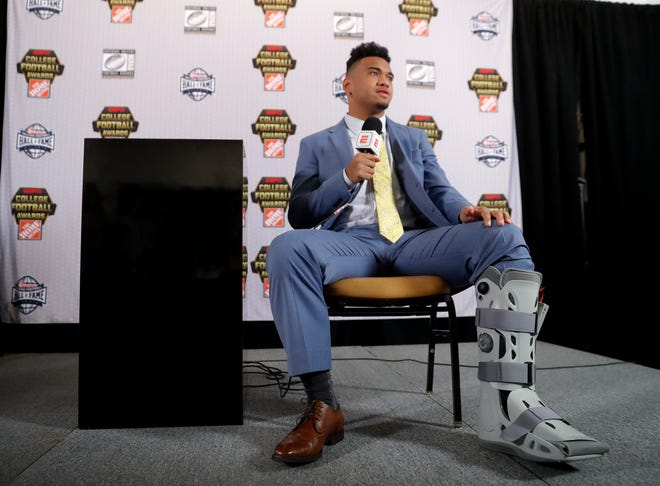 Alabama quarterback Tua Tagovailoa wears a protective boot on his injured foot as he speaks to reporters after winning the Maxwell Award and the Walter Camp honor, Thursday, Dec. 6, 2018, in Atlanta. Tagovailoa was injured in the Southeast Conference championship game against Georgia. (AP Photo/John Bazemore)