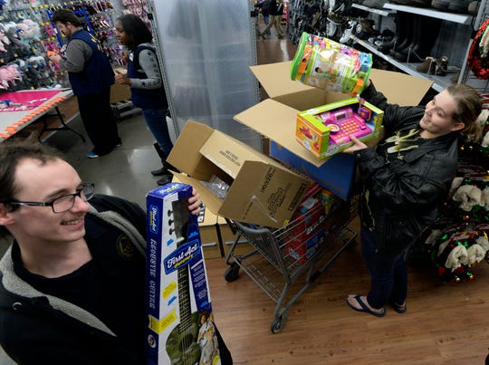 Autumn and Woody Nuncio show the Christmas gifts they had on layaway at a Walmart store on Saturday, Dec. 8, 2018, in Nashville, Tenn. Kid Rock spent about $81,000 Saturday to pay off the balances of 350 layaway accounts, including the one belonging to the Nuncios, at the Dickerson Pike store.