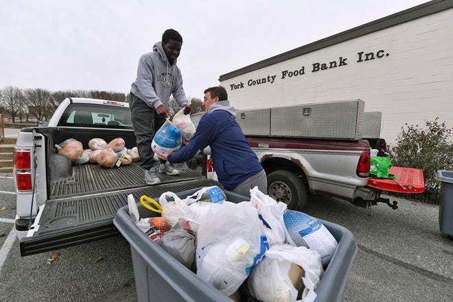 Jamal Brandon, left, and Raymond Christas, both 17, from Dallastown, unload donated turkeys at the York County Food Bank, Sunday, December 9, 2018. The volunteers from the Dallastown football and wrestling teams, picked up turkeys donated during the first ever "Bring York Turkey to Church Day." Six area churches encouraged their members to bring a turkey to worship service during the event.  John A. Pavoncello photo	